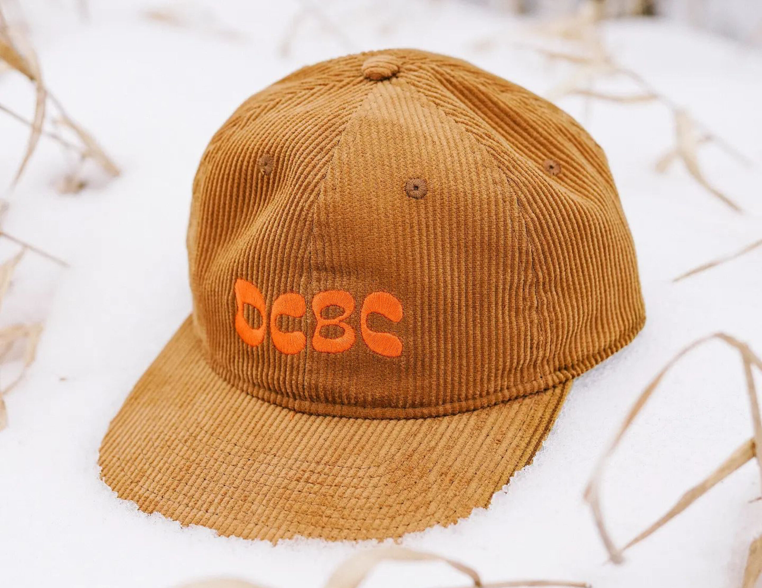 Orange DCBC branded brown corduroy hat.